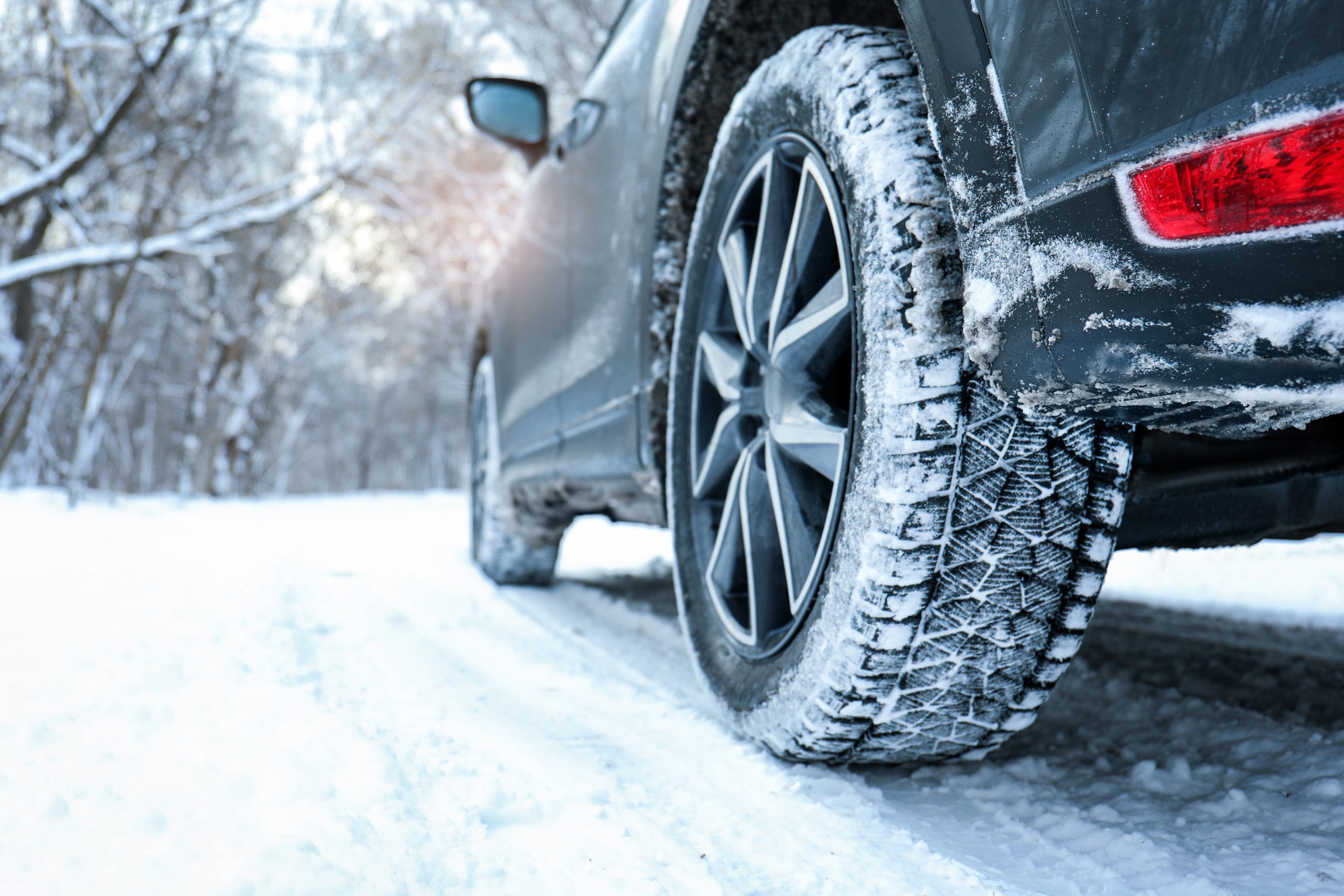 Snowy country road with car on winter day, closeup. Space for te